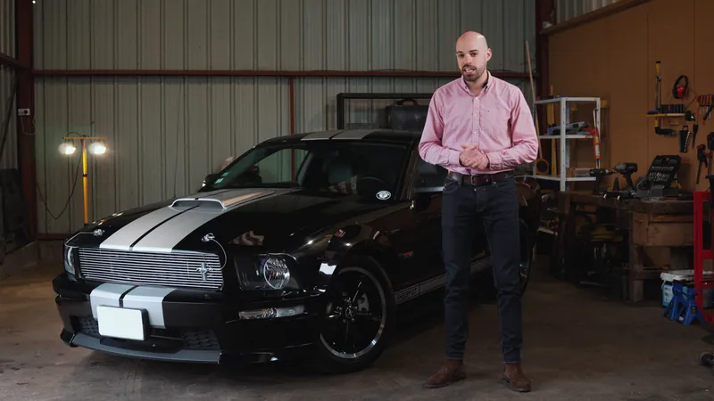 Brenn présente une Ford Mustang Shelby GT 2007 noire à bandes argent dans un garage